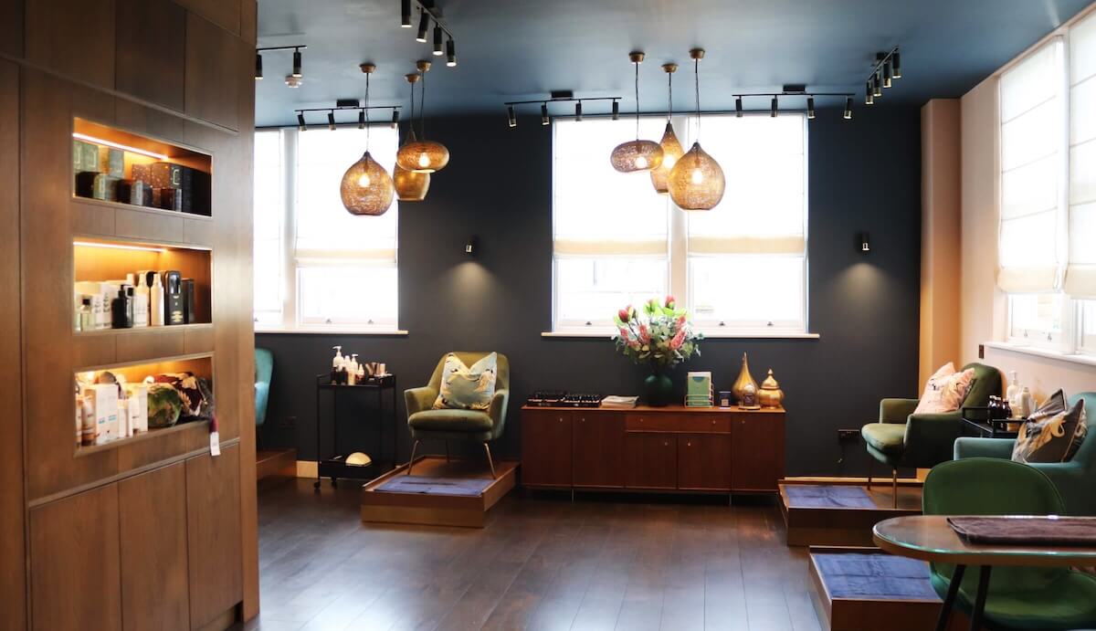 An modern and luxe open space of a beauty salon featuring a manicure and pedicure stations.