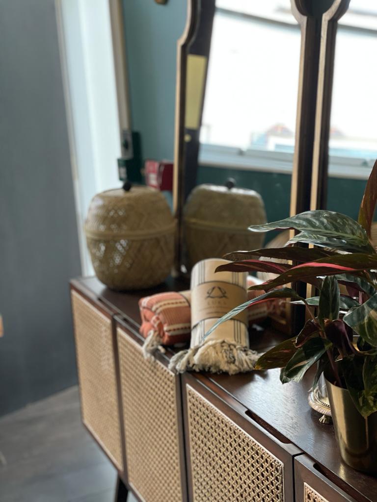 Interior details of a beauty salon featuring two Turkish towels on a rattan side bench. 