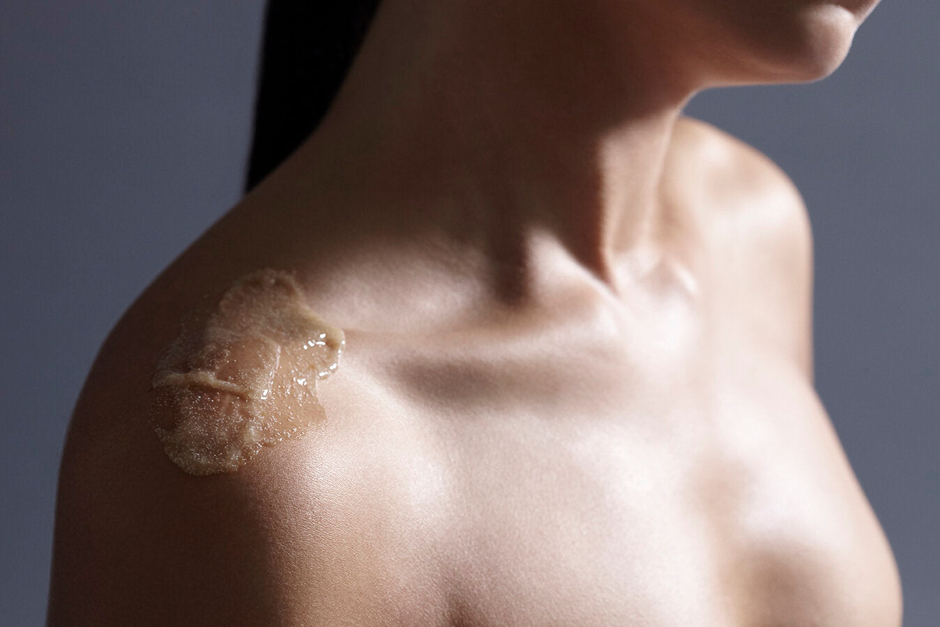 Landscape close up a model's décolletage with a moisturising serum to be applied pre massage and body treatments.