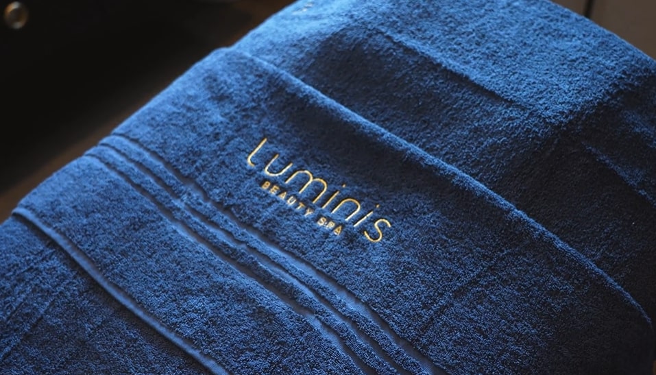 A close up of a Luminis Branded navy towel. 