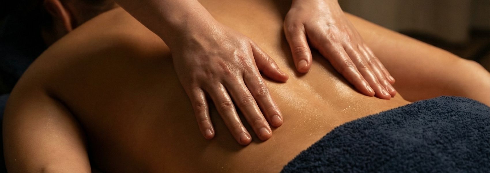 Close-up of hands giving a massage on a person's back.
