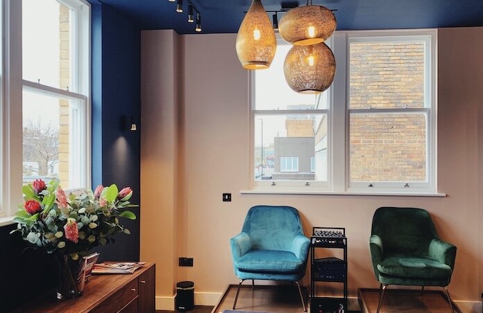 Interior details of Luminis Beauty Salon in Chiswick featuring manicure and pedicure stations and plush velvet green and blue chairs. 