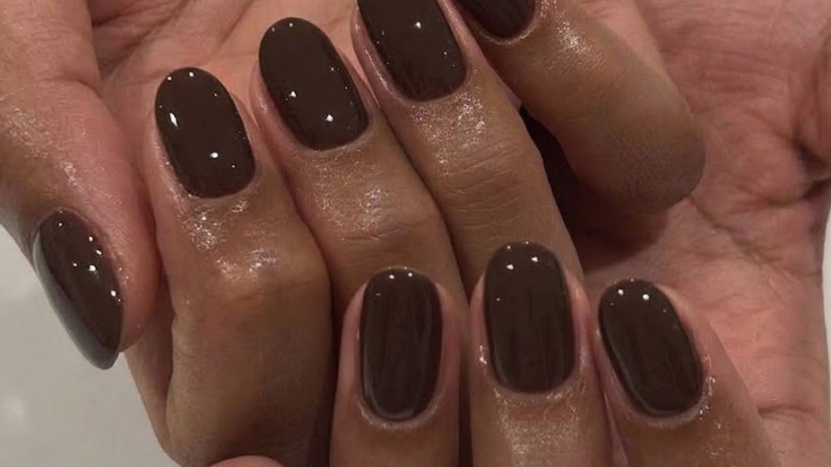 Close-up of glossy dark brown oval-shaped nails