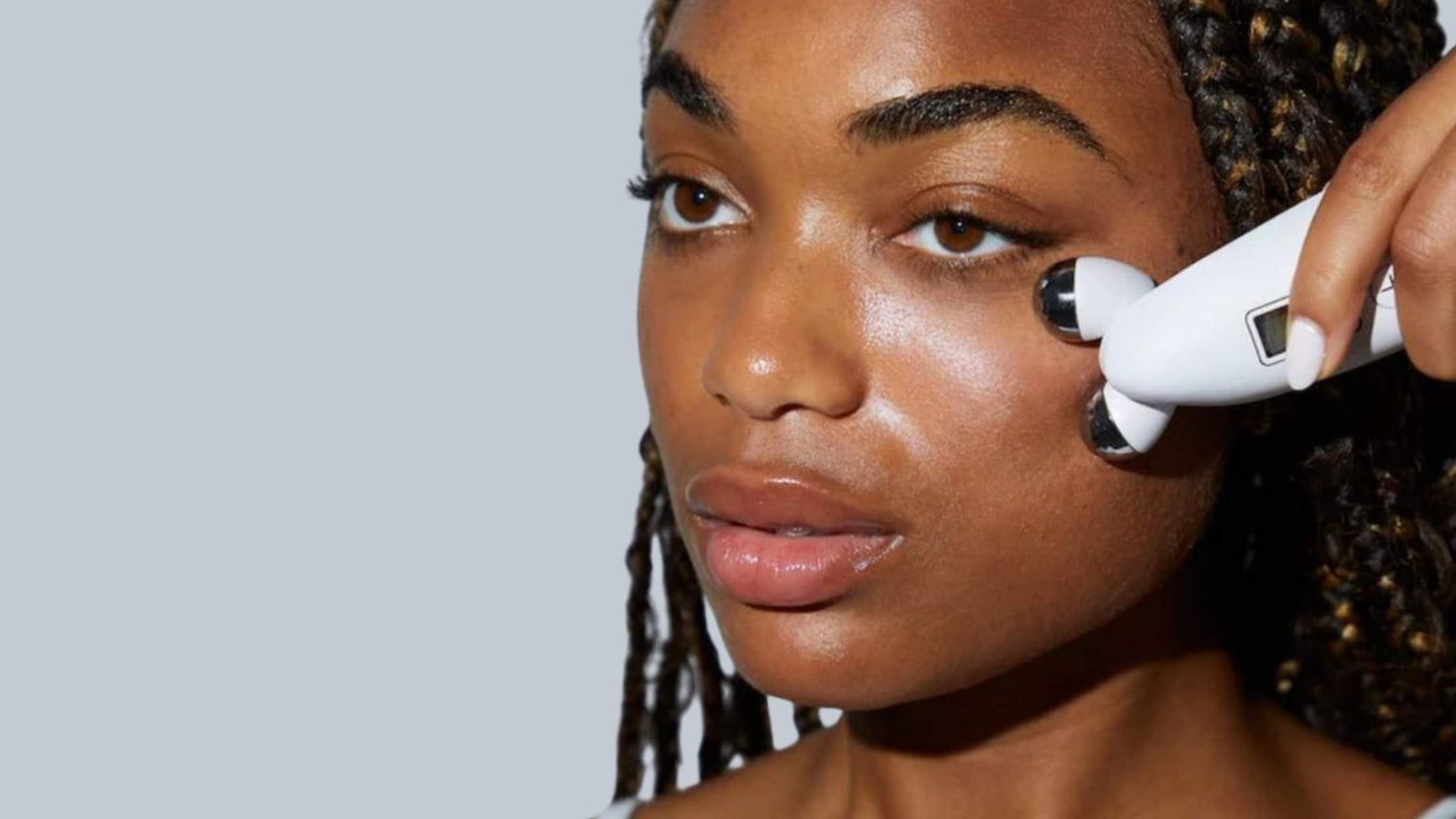 a woman holding a pure lift device close to her face at Luminis Beauty Spa