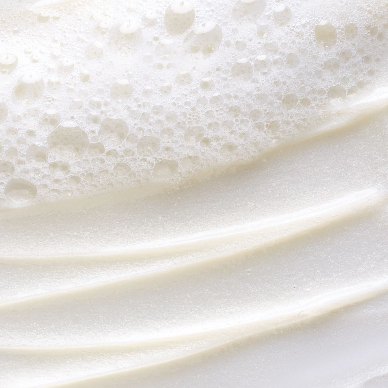 Close-up of white cream with bubbles on a white background