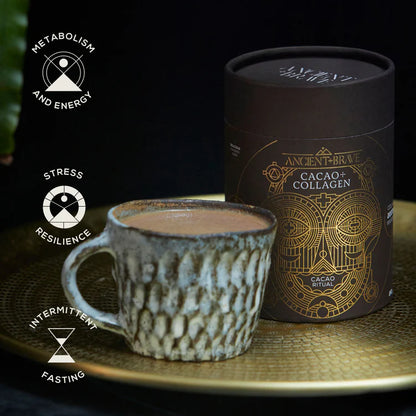 Ceramic mug with hot chocolate next to a dark brown packaging box labeled &