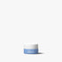 Small jar with blue base and white lid on a light gray background