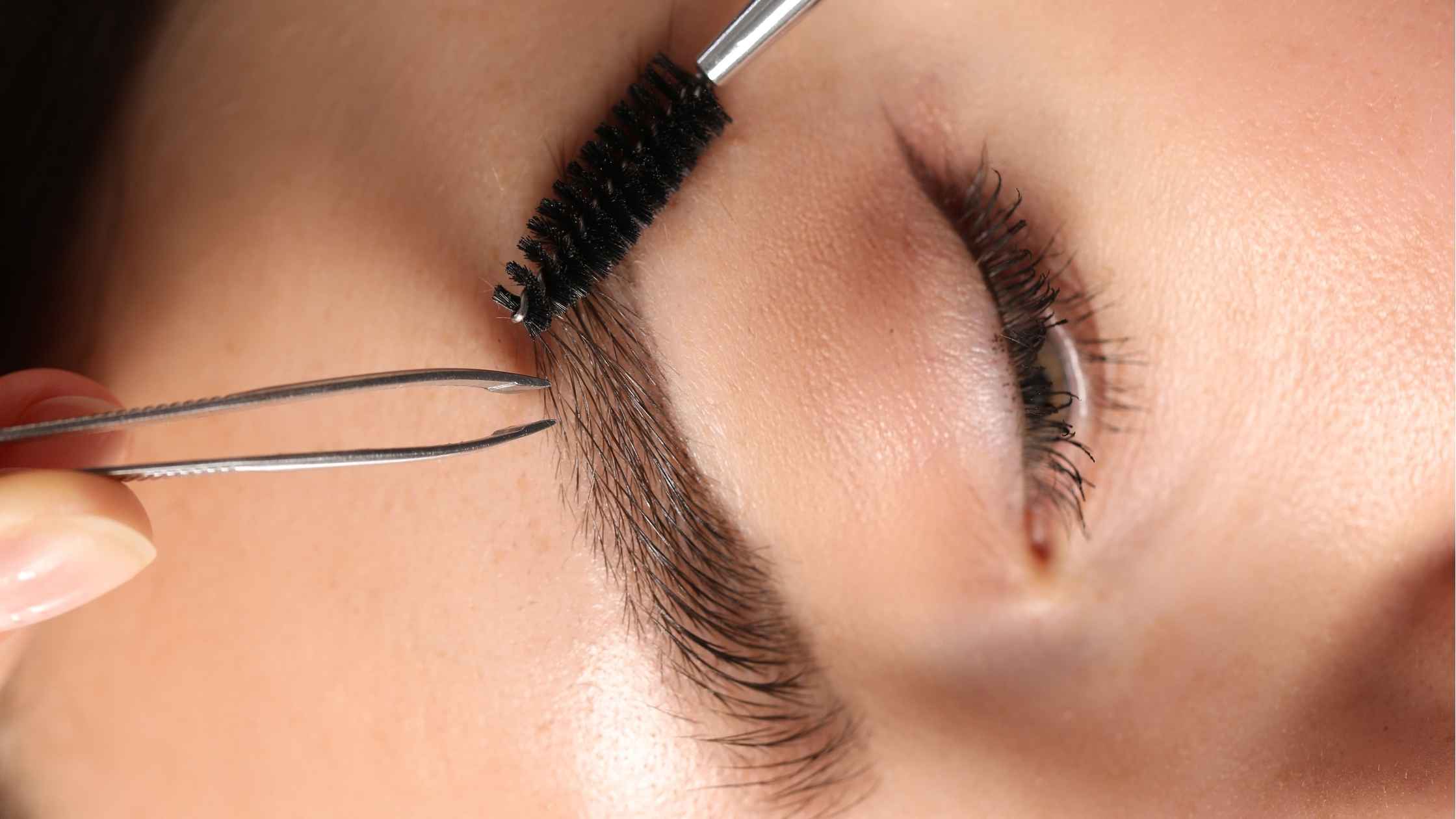 Eyebrow grooming with a brush and tweezers