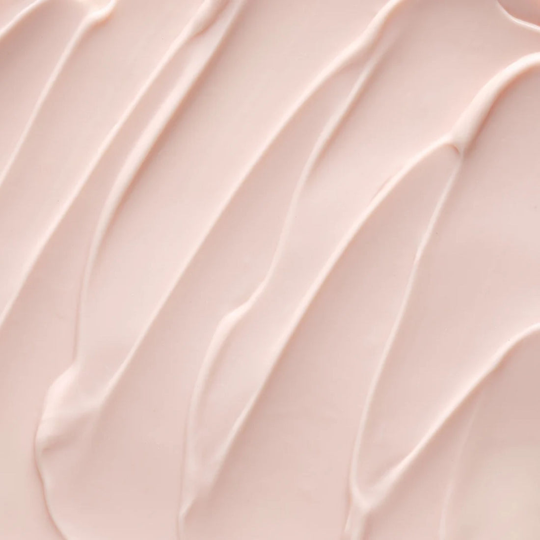 A close-up texture shot of a smooth, pale pink cream or lotion swatch with elegant diagonal swirled lines.