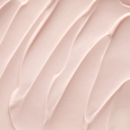 A close-up texture shot of a smooth, pale pink cream or lotion swatch with elegant diagonal swirled lines.